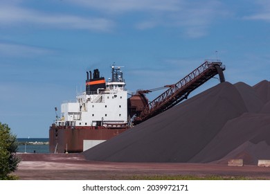 A Great Lakes bulk carrier offloads tons of iron ore (taconite) pellets to a bulk terminal at the Port of Cleveland, Ohio on Lake Erie