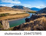 Great Missouri River. The clouds are reflected in the water. The bed of the deep river bends into the hilly banks. The Missouri River is tributary of the Mississippi River. US