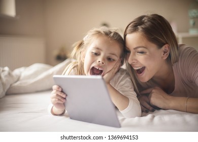 Great movie. Mother and daughter using digital tablet. - Powered by Shutterstock