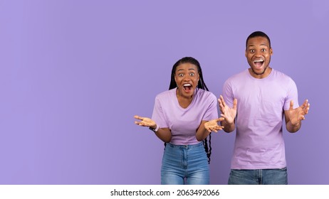 Great News Or Offer. Portrait of excited young black man and woman screaming yes with open mouth spreading hands and looking at camera. Violet purple studio wall, banner, panorama, free copy space