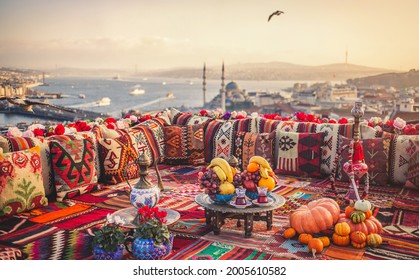 Great panoramic view of Istanbul from high terrace decorated traditional colorful ornamental pillows and carpets and stillife. Selective focus