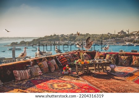 Great panoramic view of Istanbul from rooftop decorated traditional colorful ornamental pillows and carpets and stillife with fruits, turkish tea