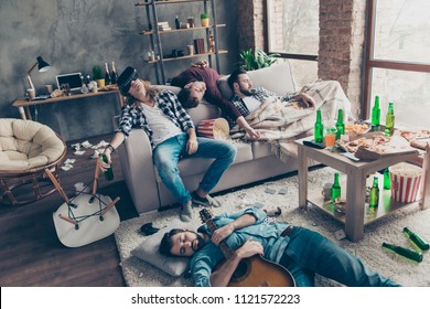 It was great party! Bearded, exhausted, tired, drunk guys are sleeping after night events on the floor and sofa in different pose in living room, having a lot of litter, garbage, rubbish around them