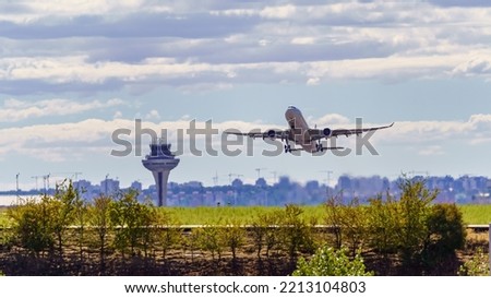 Great plane taking off and taking height next to the control tower of the airport, Madrid, Spain.