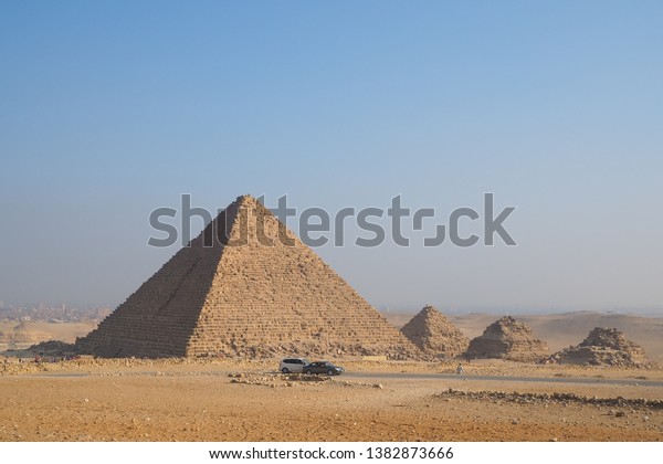 Great Pyramid Egypt seven wonder of the world \
with car in front of\
pyramid.