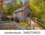 Great Smoky Mountains National Park, Tennessee,  a historic water wheel and  grist mill with a split rail fence.