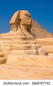 The Great Sphinx of Giza and in the background the Pyramids of Giza, the oldest Funerary monument in the world. In the city of Cairo, Egypt. Vertical photo