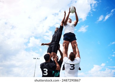 Great team mates help you reach your goals. Shot of a group of young men playing a game of rugby. - Powered by Shutterstock