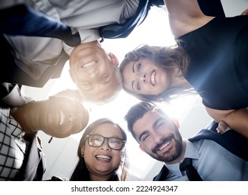 Great Things Happen When We Put Our Heads Together. Low Angle Portrait Of A Team Of Happy Colleagues Putting Their Heads Together In A Huddle In The Office.