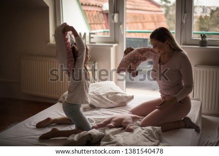 Similar – Happy boy jumping and playing over the bed with his family in a relaxed morning. Weekend family leisure time concept.