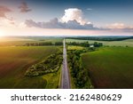 Great top view of the road passing through the agricultural lands. Location place of Ukrainian agrarian region, Europe. Aerial photography, drone shot. Photo wallpaper. Discover the beauty of earth.