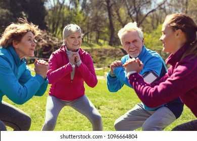 Great training. Content aged woman smiling and exercising with her friends in the park - Shutterstock ID 1096664804