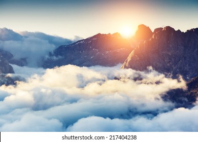 Great view of the foggy Val di Fassa valley with passo Sella. National Park. Dolomites, South Tyrol. Location Canazei, Campitello, Mazzin. Italy, Europe. Dramatic scene. Beauty world. - Shutterstock ID 217404238
