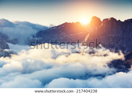 Great view of the foggy Val di Fassa valley with passo Sella. National Park. Dolomites, South Tyrol. Location Canazei, Campitello, Mazzin. Italy, Europe. Dramatic scene. Beauty world.