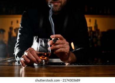 Great View Of Male Hands Holding A Glass Of Strong Alcoholic Drink And Smoking Cuban Cigar