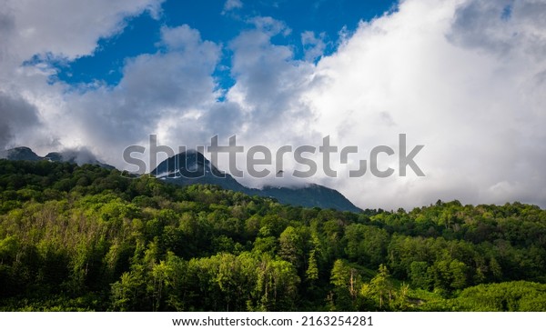 Great view of the mountains.\
Leisure and outdoor recreation. Summer view of the mountains, green\
mountains and white clouds in the blue sky. Cable car in the\
mountains.