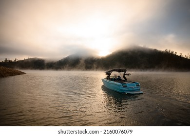 Great view on bright blue modern motor boat floating on water. Scenic view of hills and sky with cumulus clouds on the background - Shutterstock ID 2160076079