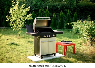 Great view on modern stainless portable BBQ barbecue grill at yard. Outdoor major kitchen appliances - Shutterstock ID 2188529149