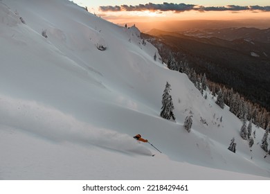 Great view of winter mountain landscape and freerider skiing down the snowy slope. Ski touring and freeride concept