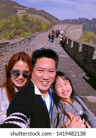 The Great Wall Of China, Beijing, A Family, Dad, Mom And Daughter, Selfie Themselves At The World's Historic Heritage And Landmark.  There Are The Walls Behind But No Walls Between Us.