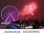 Great wheel of Montreal. Panoramic colorful silhouette by night. Colorful fireworks explode near the observation wheel at night. luminous colorful ferris wheel in the Old Port.