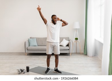 Great Workout Playlist. Cheerful African American Man Wearing Headphones Exercising At Home. Fitness Music Application For Sport Training Concept. Full Length