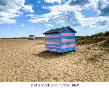 Great Yarmouth Beach Cabins In A Summer Day, Traditional UK Cabin On An English East Coast, Blue And Pink Horizontal Stripes, Sky With Clouds No People, Large Stretch Of Sand, UK Beaches