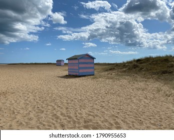 Great Yarmouth Beach Cabins In A Summer Day, Traditional UK Cabin On An English East Coast, Blue And Pink Horizontal Stripes, Sky With Clouds No People, Large Stretch Of Sand, UK Beaches