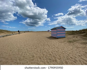 Great Yarmouth Beach Cabins In A Summer Day, Traditional UK Cabin On An English East Coast, Blue And Pink Horizontal Stripes, Sky With Clouds No People, Large Stretch Of Sand, UK Beaches