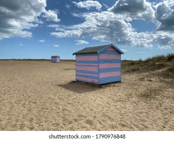 Great Yarmouth Beach Cabins In A Summer Day, Traditional UK Cabin On An English East Coast, Blue And Pink Horizontal Stripes, Sky With Clouds No People, Large Stretch Of Sand, UK Beaches