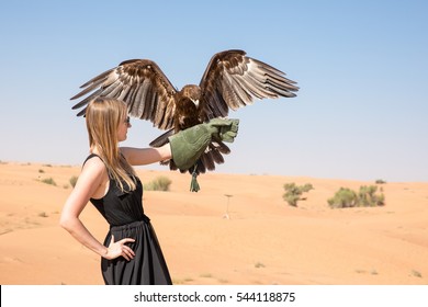 Greater Spotted Eagle (Clanga Clanga) With A Young Female Model During A Desert Falconry Show In Dubai, UAE.