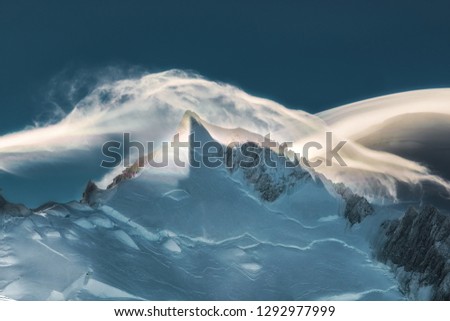 Greatness of nature. Evening panoramic view of mount Mont Blanc. Clouds flowing over the mountain top.