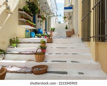 Greece, Andros island, Cyclades. Souvenir shop Greek art, variety of pots with plants outdoors on whitewashed stone paved stairs at Chora town. - Shutterstock ID 2213345903