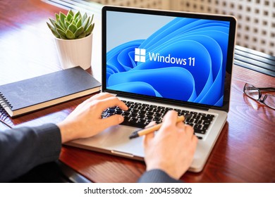 Greece Athens, July 8 2021. Man Working With A Laptop, Windows 11 New Microsoft Operating System On Computer Screen, Business Office Desk Background. 

