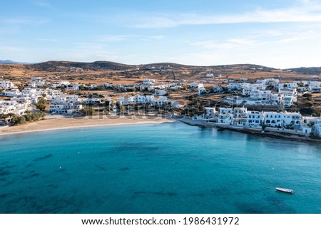 Greece, Koufonisi island, small Cyclades. Aerial drone view. Pano Koufonisi white traditional village buildings, Megali Ammos sandy beach. Calm turquise sea water, clear blue sky background.


