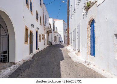 Greece, Kythira island. Empty narrow street at Chora town. Traditional houses and closed stores white color walls, blue windws and doors - Shutterstock ID 2166235731