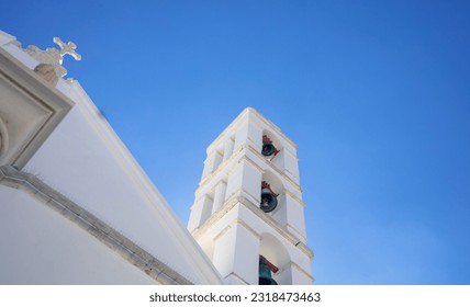 Greece, Tinos island, Chora town religious destination Cyclades. Orthodox Church Belfry of Panagia Megalohari. Blue sky background. Under view - Shutterstock ID 2318473463