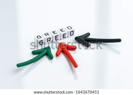 Greed and fear in stock market or money game and financial investment, multiple arrow pointing to cube block building the word GREED on clean white background.
