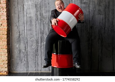 Greedy Caucasian Fat Oil Tycoon Hugs Oil Barrel. Handsome Businessman In Formal Wear Engaged In Oil Production