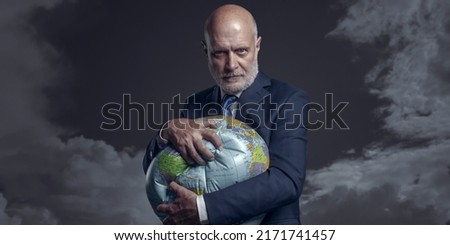 Greedy corporate businessman crushing a globe: earth exploitation and power concept Foto stock © 