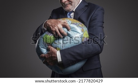 Greedy corporate businessman crushing a globe: earth exploitation and power concept Stock foto © 