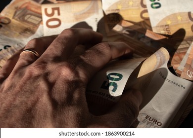 A greedy hand grabbing on a bunch of money. Concept for avidity, greed, eagerness and dirty money