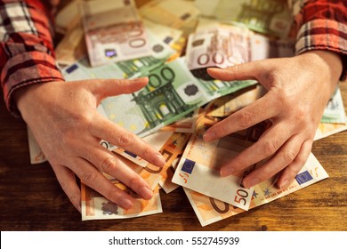 Greedy Hands Withdrawing Pile Of Euro Banknotes Cash Money On Office Desk