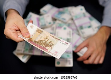 greedy men's hands reach for a wad of money. A million Russian rubles on the black table. The concept of wealth, success, greed and corruption, lust for money. capital, capitalism