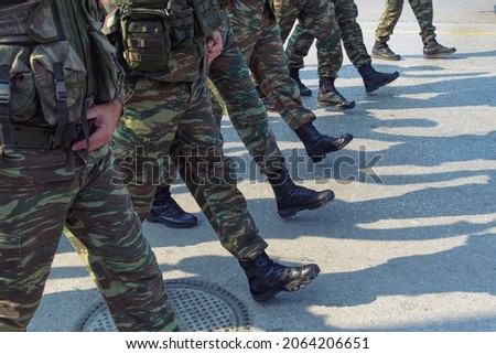 Greek Army soldiers in combat uniform during parade. Silhouette of Hellenic Armed forces males wearing black boots and battle clothing in a camouflage pattern.