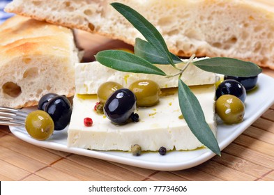 Greek cheese with green and black olives decorated by olive leaves - Powered by Shutterstock