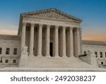 Greek classical architecture of the United States Supreme Court building with sunrise in background.