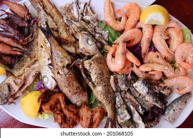 Greek Cuisine - Traditional Grilled Seafood Plate With Shrimps, Anchovy, Sardines, Squid And Other Fish.