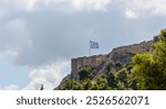 The Greek flag flies on the rock of the Acropolis