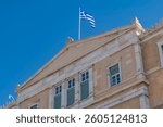 The Greek flag flies over the Parliament building in Syntagma Square, Athens, Greece